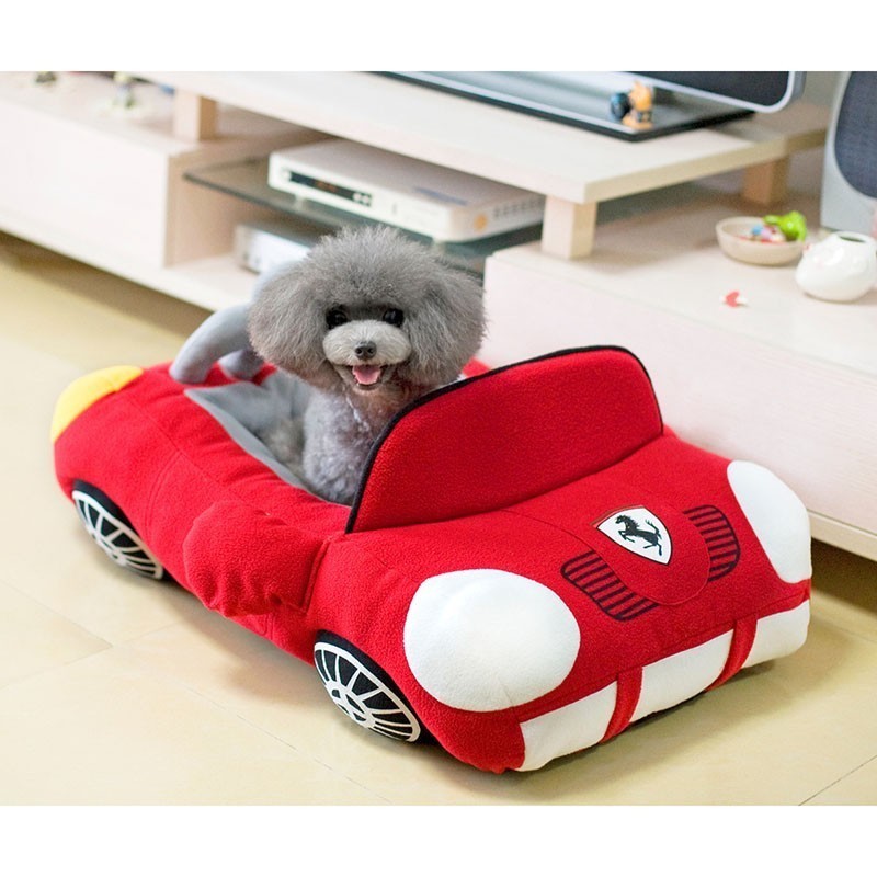 A car-shaped pet toy with a black and gray interior and white cotton exterior, featuring a peace sign on the front.