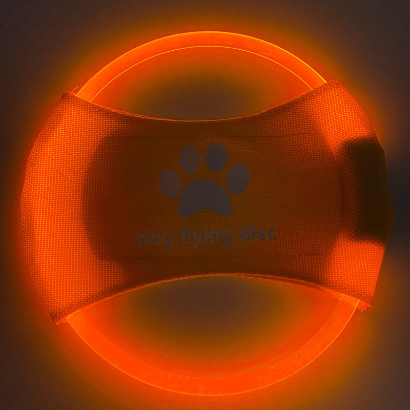 A dog catching a red glowing LED frisbee with other color options shown in separate images. The frisbee is rechargeable and appears to be made of a soft, durable material.