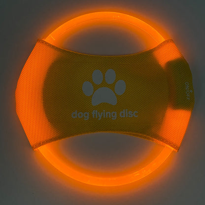 A dog catching a red glowing LED frisbee with other color options shown in separate images. The frisbee is rechargeable and appears to be made of a soft, durable material.