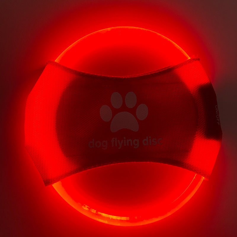 A dog catching a red glowing LED frisbee with other color options shown in separate images. The frisbee is rechargeable and appears to be made of a soft, durable material.
